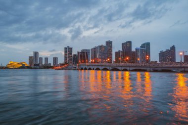 Miami, Florida şehir merkezi Biscayne Körfezi 'nde. Günbatımında şehir gökdelenleri ile Panorama ve yansıma ile deniz üzerinde köprü.
