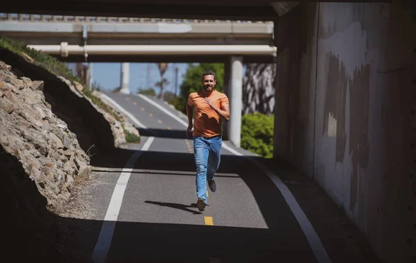 Een atletische jongeman. Rennende hardloper sprinten workout op de stad weg. — Stockfoto