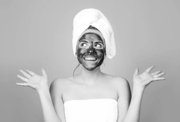 Maschera viso fango, maschera viso argilla spa. Bella donna eccitata divertente con procedura viso fango cosmetico, concetto di salute spa. Cura della pelle trattamento di bellezza. Asciugamano sulla testa. Fango minerale medico. — Foto Stock