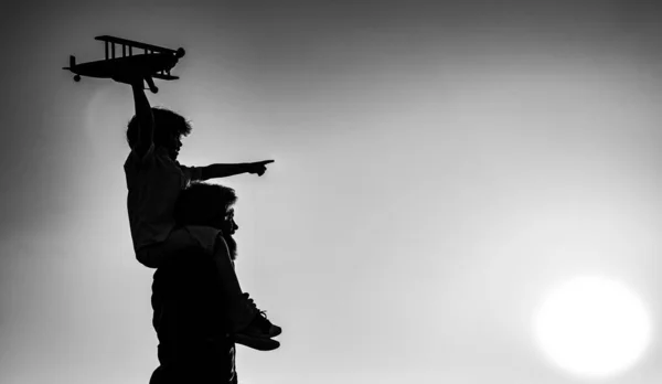 成功と子供のリーダーの概念。父と息子の日没のシルエットを一緒に。男の子子供は座っていますパパ肩のピギーバック飛行中. — ストック写真