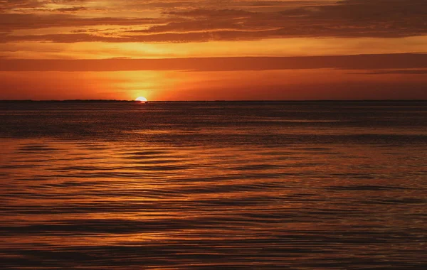 Sole al tramonto sull'acqua dell'oceano. Colori naturali del cielo. Mare del sole all'alba. — Foto Stock