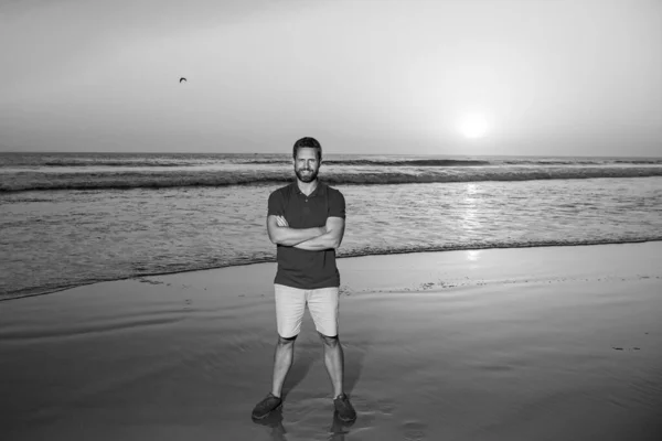 Красивый мужчина в футболке, позирующий в морских пейзажах. Путешествие отпуск. Привлекательный мужчина прогулки на пляже океана, насладиться тропическим сезоном. — стоковое фото