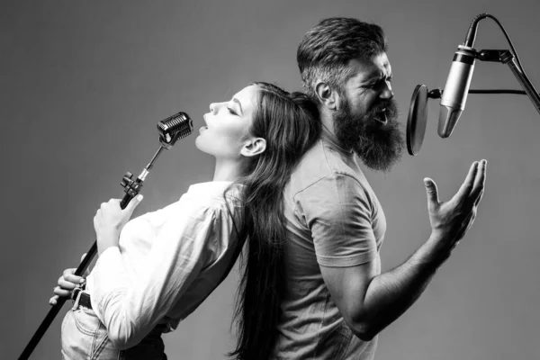Pár zpěvu. Zpívající muž a dívka v nahrávacím studiu. Výrazný pár s mikrofonem. Karaoke signer, hudební zpěvák. — Stock fotografie