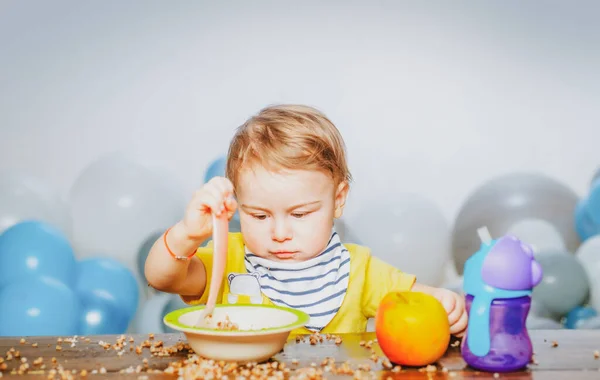 Linda comida para bebés, bebés comiendo. Chico divertido con plato y cuchara. — Foto de Stock