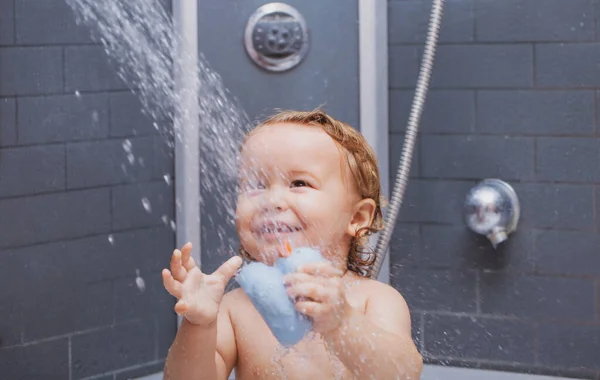 Zwemmende lachende baby. Gelukkige jongen met zeepschuim op zijn hoofd. Grappig kind onder de douche. — Stockfoto
