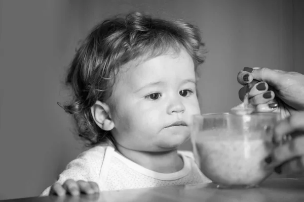 Voed baby. Moeder voedt haar zoontje met fruitpuree. Gezonde voeding voor kinderen. — Stockfoto