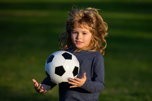 Παιδί του ποδοσφαίρου παίζει ποδόσφαιρο. Αγόρι που κρατά μπάλα ποδοσφαίρου, κλείστε σπορ παιδιά πορτρέτο. — Φωτογραφία Αρχείου