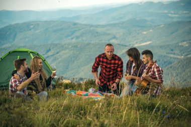 Kamp gezisindeki gençler. Dağ yamacında yürüyüş yapan genç kızların ve erkeklerin aktif arkadaşları..