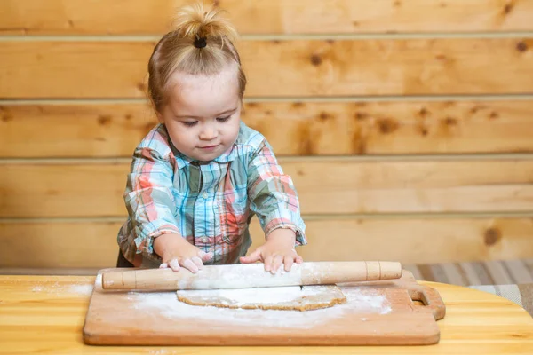 Criança de padeiro na cozinha. Menino na cozinha ajudando com a cozinha, brincando com a farinha. — Fotografia de Stock