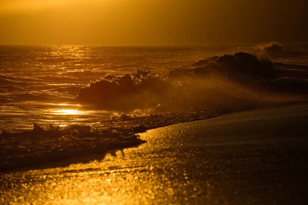 Золотое небо и океанская вода. Волны брызги. Закат над морем с золотой драматической панорамой неба. Спокойное море с закатом неба. Океан и небо. — стоковое фото