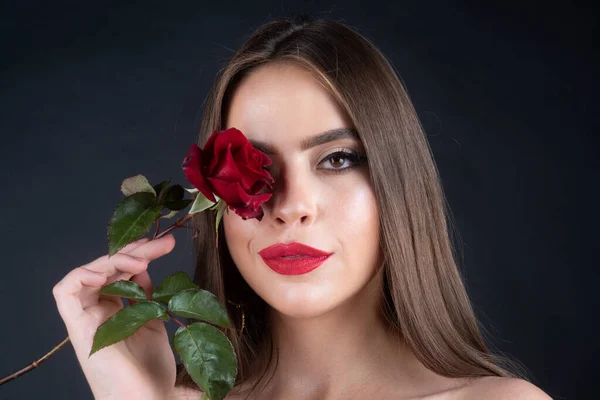 Portrait de mode de jeune belle femme à la rose rouge. Gros plan portrait d'une belle jeune fille avec une rose près du visage. Portrait inaltéré. Texture naturelle de la peau. — Photo