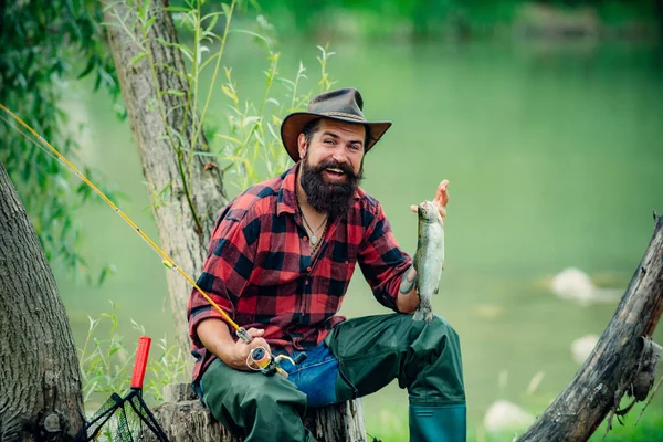 Pescador con caña de pescar en el río de montaña. Un pescador de mosca pescando trucha silvestre en el río en el bosque. — Foto de Stock