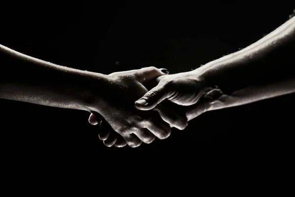Hände gestikulieren auf schwarzem Hintergrund. Hilfe leisten. Unterstützung und Hilfe, Zustimmung. Hände zweier Retter. Helfende Hand zur Rettung ausgestreckt. Händedruck zwischen den beiden Partnern. — Stockfoto