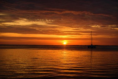 Yumuşak dalgalı tropik plaj ve soyut gökyüzü. Deniz manzarasında gün batımı. Bulutlu dramatik günbatımı gökyüzü. Denizin üzerinde dramatik gün batımı.