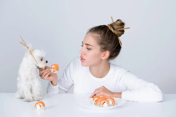 Japanisches Sushi. Modeporträt der Schönheit Modell Mädchen essen Sushi-Rollen, japanisches Essen. Schöne Frau mit Essstäbchen und Sushi. Sexy Dame mit Hund-Werbung. — Stockfoto