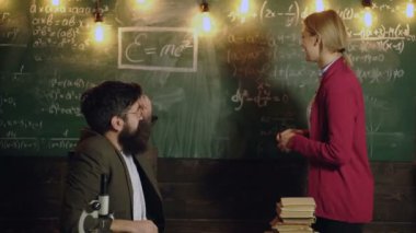 Matematik okulunda matematik dersi öğretmeni. Üniversitedeki kadın ve erkek tahtada. Bir sınıfta ders veren bir profesör, eğitim konsepti. Matematik dersi. Matematik bilimi.