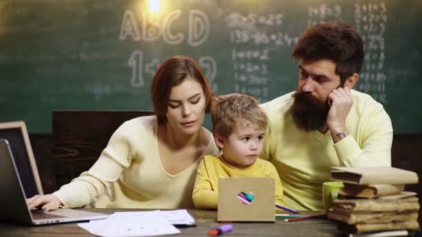 Mamma och pappa med barn som skriver hemma. Föräldrar som lär barn. Familj i tidig utveckling koncept. Far mor och barn son måla tillsammans hemma. — Stockvideo