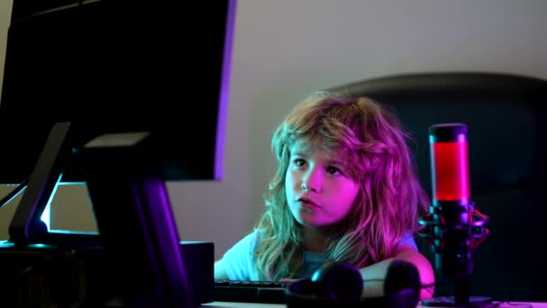 Niño en la pantalla de la computadora PC. Lindo niño preescolar está viendo películas por escritorio. Escuela, estudio, concepto de aprendizaje en línea. Colegial escribiendo en el teclado. — Vídeo de stock