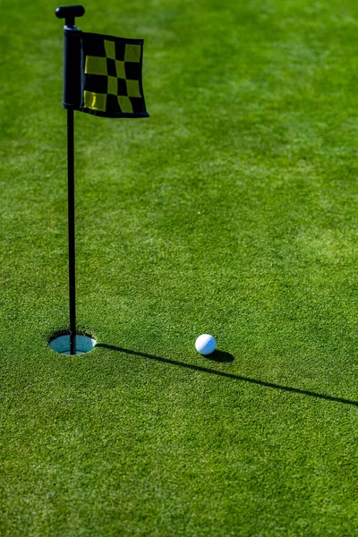 Trou de golf. Boule de golf sur lèvre de tasse sur fond d'herbe. — Photo