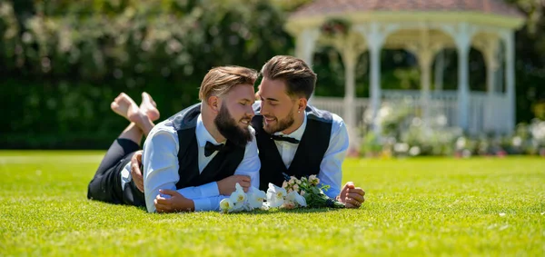 Wakacje, Festiwale, i Wydarzenia koncepcja lgbt. gej małżeństwo para układanie na trawa na ślub dzień. — Zdjęcie stockowe