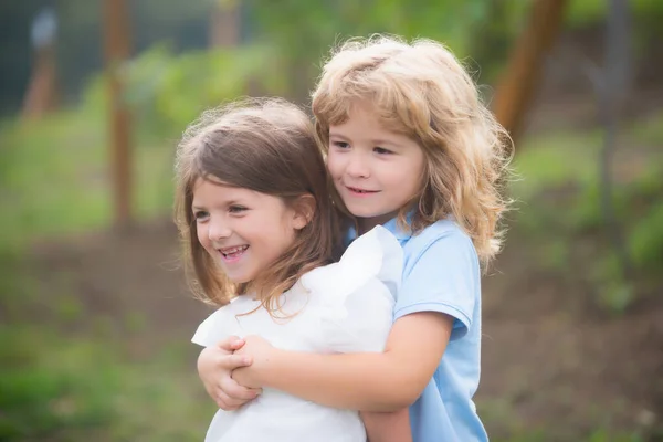 Kleiner Bruder und Schwester, Junge und Mädchen beim Spielen im Freien. Glückliche Kinder, die Spaß im Freien haben. Bruder und Schwester spielen im Frühlingspark. Kinderfreundschaft und Freundlichkeit. — Stockfoto