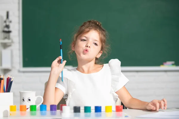 Kind meisje tekening met kleurpotloden verven. Portret van een schattig klein meisje dat vrolijk lacht terwijl ze geniet van kunst en ambachtelijke lessen op school. Voorschools onderwijs. — Stockfoto