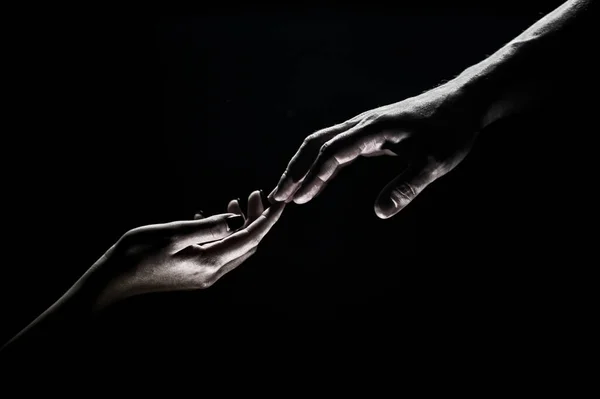 Handen gebaren op zwarte achtergrond. Een helpende hand bieden. Steun en hulp, redding. Handen van twee mensen op het moment van de redding. Romantische aanraking met vingers, liefje. Handcreatie van Adam. — Stockfoto