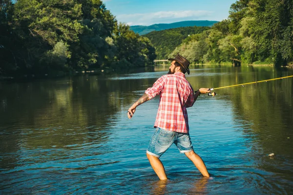 Fishing hobby and summer weekend. Bearded men fisher with fishing rod and net. — ストック写真