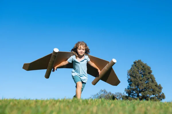 空に翼を持つ少年の子供は、飛行のパイロットと夢を想像しています。子供の冒険、子供の自由と想像力の概念. — ストック写真