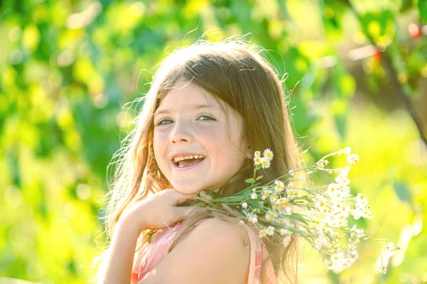 Charmant blond meisje op de achtergrond van bloemen in de zomer. mooi klein kind werken in de tuin, kind verzorgen van bloemen, genieten van warme en zonnige dag. — Stockfoto