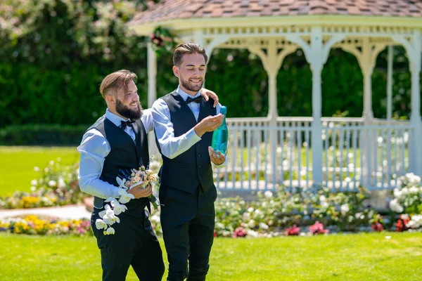 Гей пара відкриває ігристі вина шампанського. Весілля. Гомосексуальна пара святкує весілля, ЛБГТ-пара на весільній церемонії, ЛГБТ-спільнота. — стокове фото