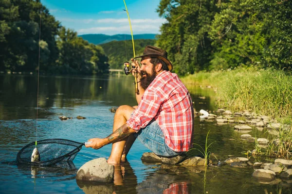 Fisherman using rod flyfishing in mountain river. A fly fisherman fishing for wild trout on the river in the forest. Catching trout fish. —  Fotos de Stock