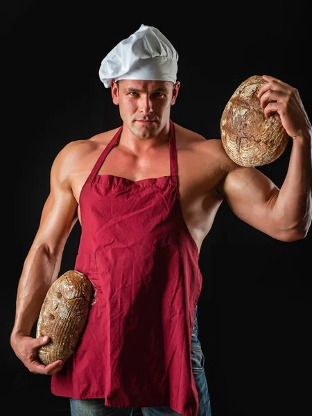 Sexy man with bread, whole grain bread. Chef holding fresh bread, bakery concept. — Stock Photo, Image