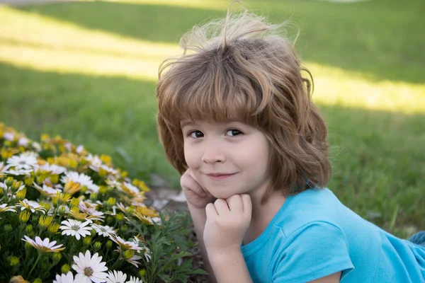 Piccolo bambino all'aperto ritratto ragazzo sul prato. Ragazzino carino con dei fiori in giardino. I bambini giocano all'aperto. Il bambino gioca all'aperto. Concetto di infanzia felice e svago estivo. — Foto Stock