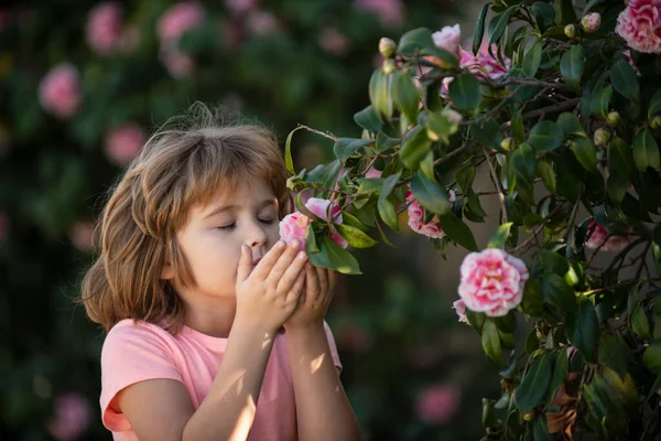 Niño rubio encantador sobre fondo de flores en verano. Niño bonito trabajando en el jardín, cuidando las flores, disfrutando de un día cálido y soleado. — Foto de Stock