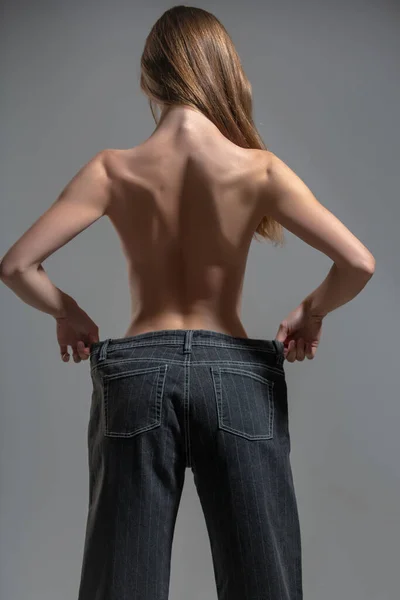 Mulher magro em jeans oversize, conceito de perda de peso. — Fotografia de Stock