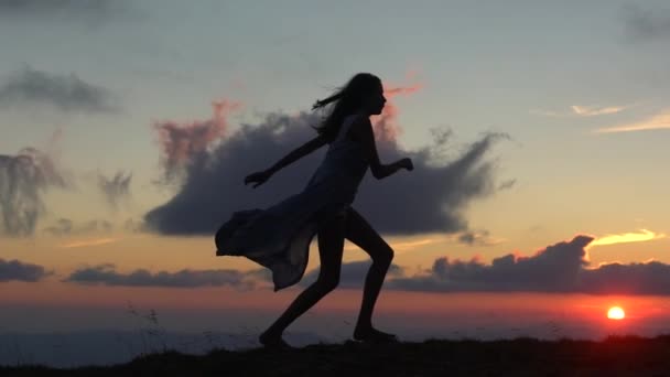 Jumping woman and sunset silhouette. Girl movement over sunset light. Free young woman at golden sunset. Freedom and success concept, enjoying nature. — Vídeos de Stock