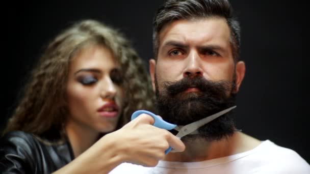 Female barber. Woman hairdresser cuts beard handsome man at barbershop. Beard care. — Video Stock