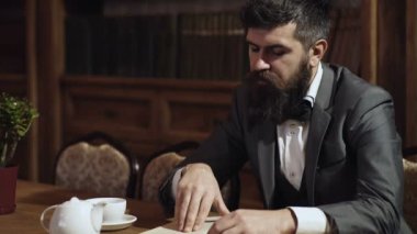 Kütüphanede sakallı adam ve arka plan kitapları. Orta yaşlı bir adam kütüphanede kitap okuyor. Hukuk ve adalet kavramı.