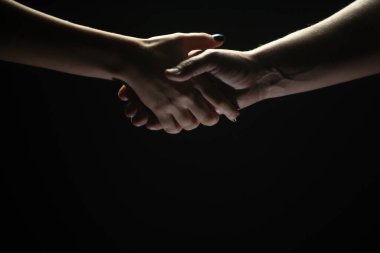 İki ortak arasında tokalaşma. Kurtarmak ya da el hareketlerine yardım etmek. Kurtuluş kavramı. Kurtarma sırasında iki kişinin elleri, anlaşma, yardım. Siyah arkaplanda izole.