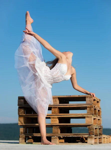Balletto d'arte. Ragazza flessibile e con le gambe divise. Giovane bella donna in abiti sportivi facendo stretching prima dell'allenamento all'aperto. Adatto al corpo e alla vita mentale sana. — Foto Stock