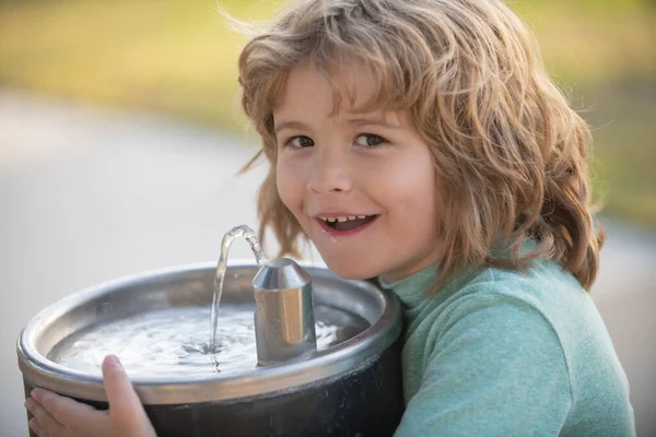 Face close up portrait of kid drinking water from outdoor water fountain outdoor. — стоковое фото