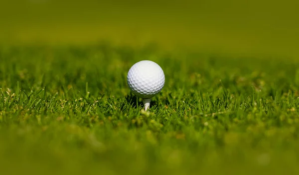 Golfový míček na odpališti připraven k výstřelu. Golfový klub pozadí. — Stock fotografie