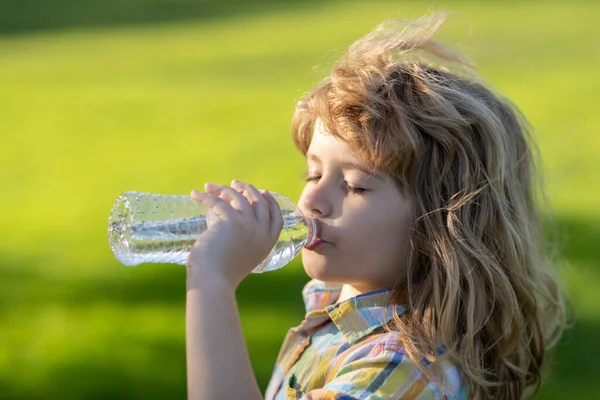 Close up portrait of kid drinking water from pet bottle outdoor. — Foto Stock