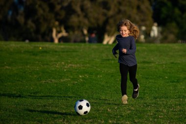 Futbolcu çocuk futbol oynuyor. Çocuk dışarıda futbol oynuyordu. Çocuk futbol topunu tekmeliyor.