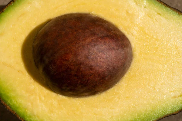 Half avocado macro, close up. Raw Fruits healthy green food. Avocado on wooden background. — Foto de Stock