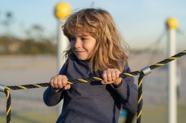 Çocuk parkında oynarken sevimli küçük çocuk komikliği. Yaz, çocukluk, eğlence ve çocuk konsepti.