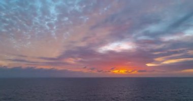 Denizde gün batımı güzel bulutlarla. Deniz ya da okyanus gün batımı zaman aşımı. Gökyüzünün arka planı Bulutlu gökyüzü, gündoğumu kumsalı.