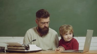 Dizüstü bilgisayarı olan baba ve oğlu. Klasik daktilo modern dizüstü bilgisayara karşı. Teknoloji kuşağı savaşı. Baba oğul gelişimi. Gençlik yaşlılığa karşı. Eski ve genç kavramları. Genç yetişkin konsepti.