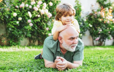 Büyükbaba, Oğul ve Torunuyla Park 'ta eğleniyor. Mutlu son sınıf çocuğunun portresi. Gülümseyen baba ve mutlu şirin oğul..